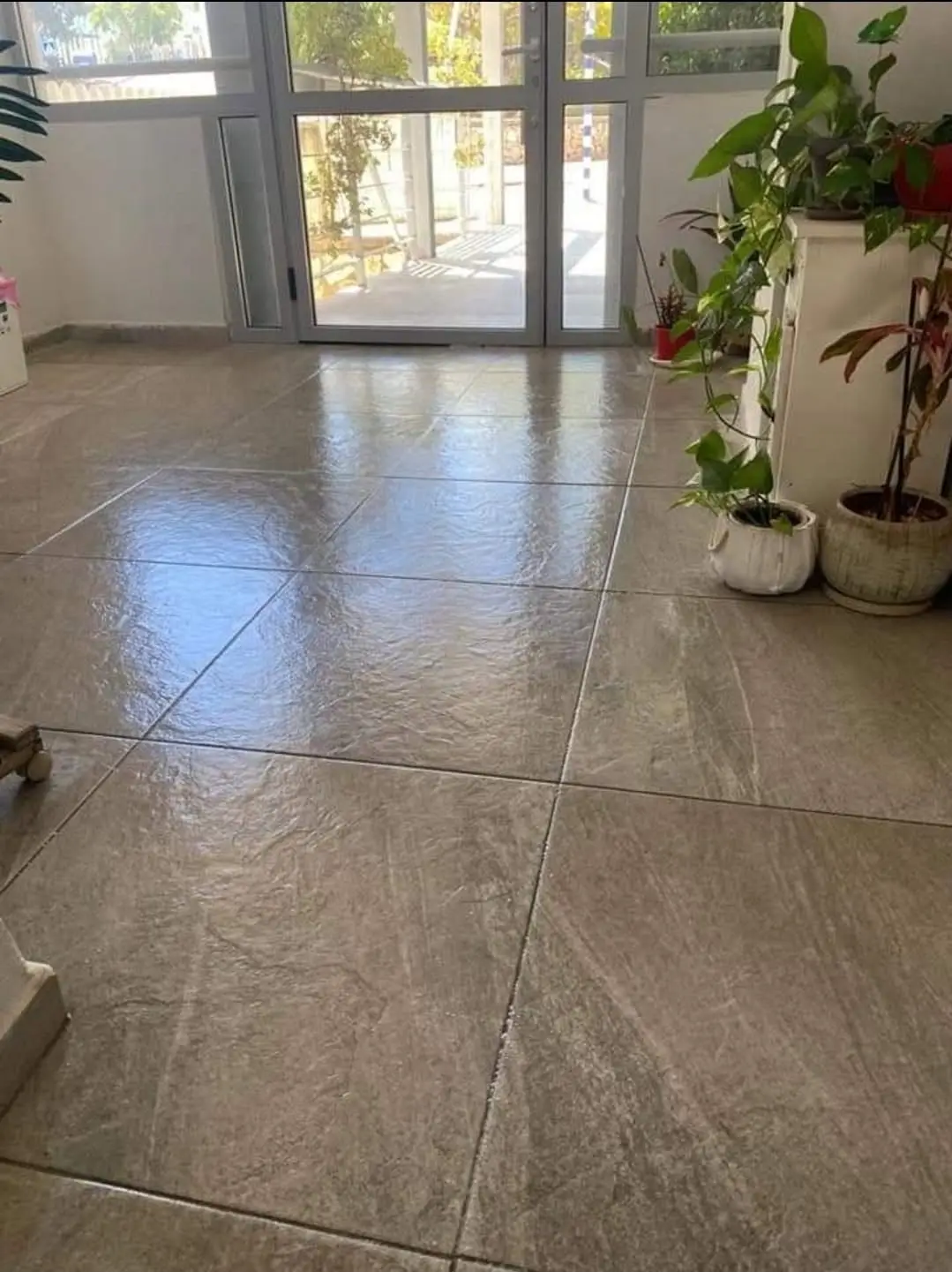 לובי כניסה בבניין מגורים בנשר אחרי שטיפה: רצפה נקייה ומשקפת ודלתות זכוכית לכניסה